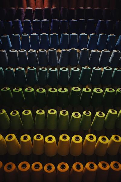 Bobinas de fio tingido em várias cores, arrumadas em filas