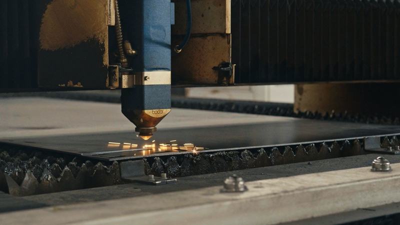 Cabeça de corte a laser sobre uma chapa metálica, numa oficina de metalomecânica